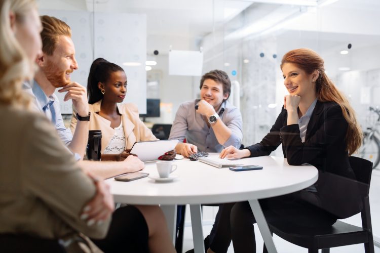 Business people board meeting in modern office while sitting at round table