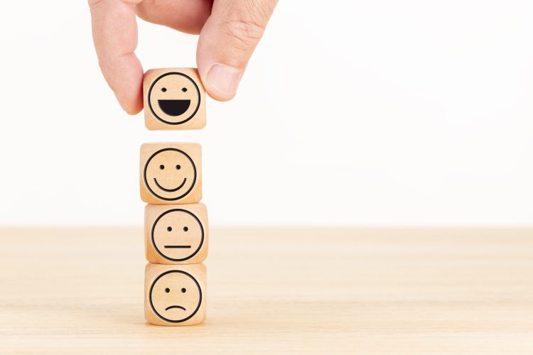 Customer service evaluation and satisfaction survey concept. Hand picked the happy face emoticon on wooden blocks. Copy space